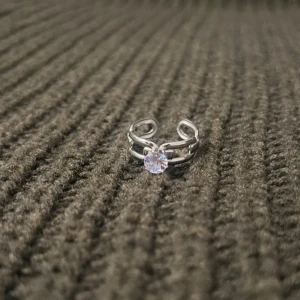 Sleek Minimal - Silver Ring with Stone - US storlek 7, diameter 17,3 mm, omkrets 54,4 mm. En stilren ring med modern minimalistisk design och en subtilt gnistrande sten. Den justerbara passformen gör den bäde elegant och bekväm för alla tillfällen.