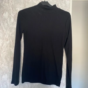 Svart ribbad polotröja från 157 - Nästan helt oanvänd. Väldigt bra skick. Från Lager 157.
