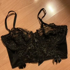Bh 80B - Korsett bh Svart med guldtrådar  Knäppning fram 