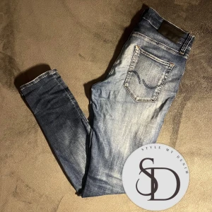 Blå slim jeans från Jack & Jones - Säljer ett par snygga blå slim fit jeans från Jack & Jones, modell slim/glenn. De har riktigt snygga slitningar och är bara använda några gånger, skick 7/10, pris 200kr