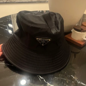 Svart buckethat  - Svart buckethat med märke på, oanvänd med prislapp kvar