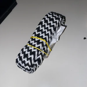 Flätat bälte - Bältet är i svart och vit randig mönster och är skitsnygg. Bältet är just nu inplastat och ihop satt med en gummisnodd. Vill man ha fler bilder skriv till mig! 