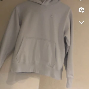 Tröjor  - Säljer en snygg orange hoodie från Tommy Hilfiger med deras klassiska logga på bröstet. Den har en känguruficka och vita snören i huvan. Perfekt för en casual look eller när du vill ha något bekvämt men stiligt. Passar både till vardags och chillkvällar.