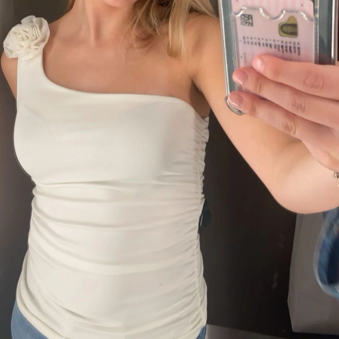 Vit oneshoulder topp med blomdetalj