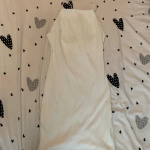 Vit Klänning HM  - Vit klänning från HM i storlek S. Lite öppen i ryggen som visat i bilden. ALDRIG ANVÄNT!