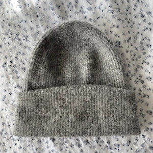 Mössa frön Samsøe - Grå ullmössa från Samsøe Samsøe. Håller värmen bra och nopprar inte. Färgskiftning på insidan av mössan från smink (se sista bilden), inget man ser när man har på sig mössan då det är på insidan, i övrigt väldigt fint skick!