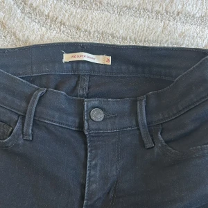 Svarta skinny jeans från Levi's - Säljer ett par nästintill oanvända svarta skinny jeans från Levi's, modell 710 Super Skinny. Storlek 26. De är i bra skick och har en snygg, tight passform. Perfekta för både vardag och fest! 🖤