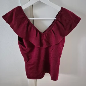 Off-shoulder topp HM - Vinröd tröja från HM. Off-shoulder topp. Stechbar material som formar efter kroppen. Nyskick, aldrig använd. Går att ha ärmarna runt armar alt runt axlar. Storlek S. Material viskos, elastan och polyamid.