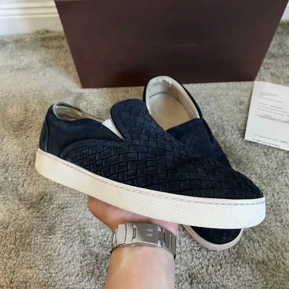 Ett par Bottega Veneta slip ons i storlek 41. Bra skick förutom att dem är slitna i hälen på insidan av skon, be om bild privat. Box, dustbag och kvitto ingår. Hör av dig vid frågor eller funderingar.. Skor.