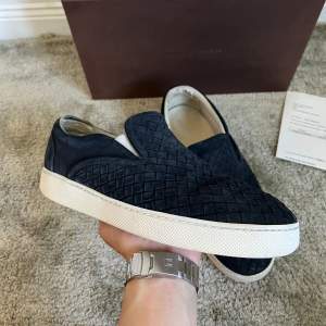 Ett par Bottega Veneta slip ons i storlek 41. Bra skick förutom att dem är slitna i hälen på insidan av skon, be om bild privat. Box, dustbag och kvitto ingår. Hör av dig vid frågor eller funderingar.