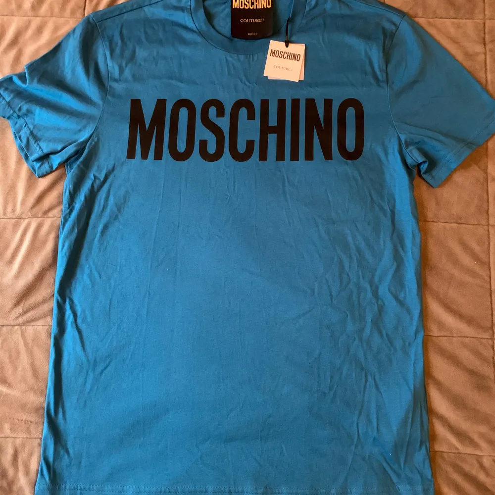 Helt oanvänd Moschino t-shirt med prislapp kvar. Nypris 1500, mitt pris 300. Storlek M Skick 10/10. T-shirts.