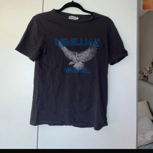 T-shirt med tryck  - Använd ett fåtal gånger, bra skick. Färgen kanske ser svart ut med skulle säga att den är mer mörk grå.