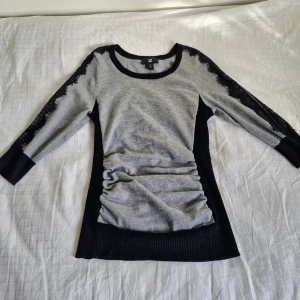 Grå och svart tröja från iZ Byer - Säljer en snygg grå och svart tröja från iZ Byer. Den har trekvartsärmar och ett coolt spetsmönster längs ärmarna. Perfekt för både vardag och lite finare tillfällen. Tröjan är i bra skick och superbekväm att ha på sig, formar även fint!