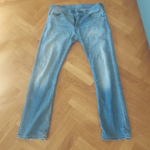 Levi's 505 jeans i ljusblå denim - Säljer ett par klassiska Levi's 505 jeans i ljusblå denim. De har en straight passform och är i bra skick. Perfekta för en avslappnad stil och funkar året runt. Levi's logga syns tydligt på bakfickan och etiketten.