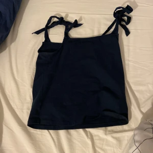 Linne med rosetter -  Säljer detta fina linne med rosetter på axlarna från HOLLY&WHYET det är Lindex märke endast använt två gånger rosetterna på banden kan man ändra och knyta om till hur man vill ha dem🩷den e marinblå