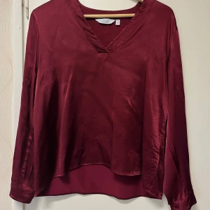 Vinröd blus  - Vinröd satin blus från other stories. Trendig färg. Storlek 40 men skulle säga absolut mer som S/36.