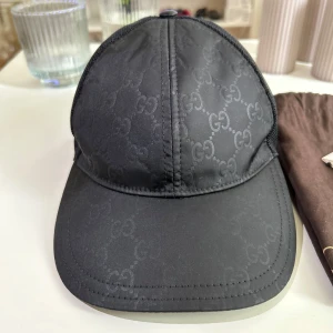Gucci GG Keps - En Gucci GG Nylon keps. Fräsch och i ett väldigt bra skick. Storlek M (58cm) Finns endast en skada som finns på bild 4. Kommer med tags och dustbag. Kan mötas upp, fraktas & Byten funkar. Pris kan även diskuteras. 