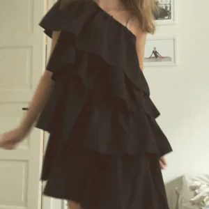 Volangklänning - (LÅNAD ANDRA BILD) Skitsnygg svart one shoulder volangklänning, storlek xs men passar mer en M. Säljer pga att den var för stor.