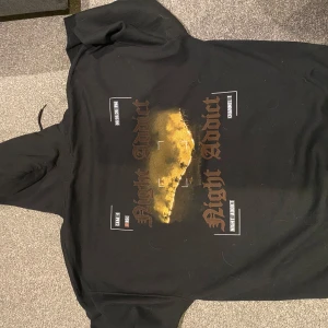 Hoddie med tryck på ryggen  - Säljer denna snygga hoddie med ett tryck på ryggen, då de inte riktigt är min stil. Den är alltså inte använd, med andra ord nyskick. 