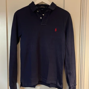 Ralph Lauren långärmad pike - Tjo, säljer nu en riktigt fin långärmad Ralph Lauren pike i storlek S samt färg mörkblå. Skick 6/10 flera små täcken på användning samt litet hål finns i högra armhålan, förutom det helt felfri. Kom dm för fler bilder/frågor osv!👊