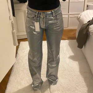 Silver glansiga jeans - Skitcoola jeans! Aldrig använda, prislapp kvar.  Har två par som jag säljer, ett par i strl S och ett par i stl M Pris kan diskuteras