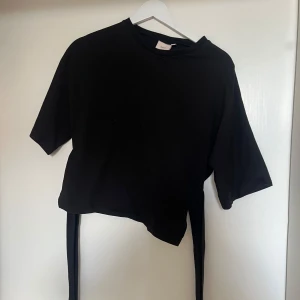 Nelly Knyt t-shirt  - Har använt tröjan ett par gånger men använder den inte längre så säljer den, man knyter den bak på ryggen lite längre ner och framifrån så ser det ut som en t-shirt men att den går in lite vid midjan ungefär💕