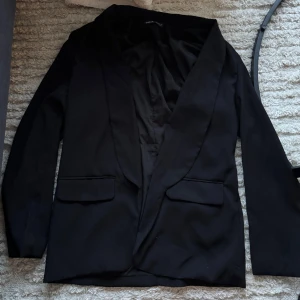 Svart kavaj från Shein - Säljer en stilren svart kavaj från Shein i storlek EU 36. Den har en klassisk design med långa ärmar och två fickor framtill. Perfekt för både vardag och fest!