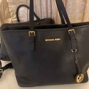 Svart axelväska från Michael Kors -  Säljer en stilren svart axelväska från Michael Kors. Väskan är i skinn och har snygga guldfärgade detaljer. Perfekt för både vardag och fest! 🖤