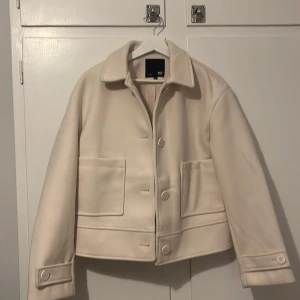 Kort kappa - Säljer en helt ny kappa som aldrig har använts! Den är i perfekt skick och passar perfekt för hösten/vintern. Storlek M och färg vit/beige. Perfekt för att hålla sig varm och stilfull. Kontakta mig för mer information eller om du vill se mer bilder! 
