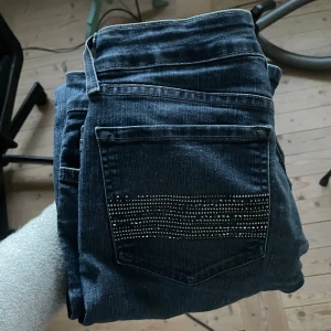 Lågmidjade jeans med coola fickor - Ett par jättefina jeans som jag själv har sytt ner lågmidjade, har används efter detta så de kommer inte att gå upp. De är även bortvittring. Jättesköna å snygga med unika fickor.   Står ingen storlek men jag skulle säga 38 
