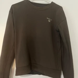 Gant tröja  - Tja , dags att sälja min Gant tröja. Det är en lite mörkare färg av grå blandat med oliv grön . Storlek Xs och är 8/10 skick . Använder inte den längre så det är darför jag lägger upp den . Hör av er vid frågor eller funderingar 
