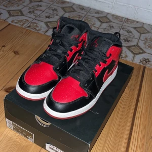 Air Jordan 1 Mid Banned strl 40  - Hej säljer mina gamla skor som jag köpte från Goat. Säljer dom för att jag har ett par andra skor. Ganska bra skick, bara en lite skroma som man kan se på bilden som jag ringa in. Annars har dom inte varit blivit använda alls. 