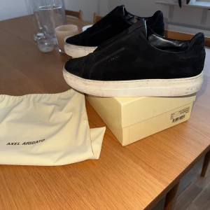  Axel Arigato - Snygga svarta sneakers från Axel Arigato i mocka. Skorna är i använt skick men går o fixa till. Jag säljer dessa skor för min fötter växt ur dem. 
