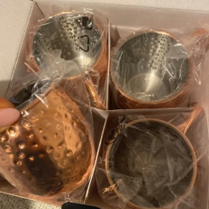Kopparfärgade muggar i set om fyra OANVÄNDA - Säljer ett set med fyra kopparfärgade muggar. Muggarna har en hamrad yta och är förpackade i en kartong. Perfekta för att servera kalla drycker med stil. Köp direkt eller ge prisförslag 💛