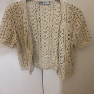 Beige stickad kofta från Zara - Säljer en söt beige stickad kofta från Zara med korta ärmar och små pärlor här och där. Hör va er vid frågor!!