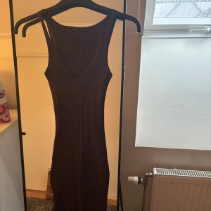 Brun ribbad klänning  - Aldrig använd. lappen är borta men skulle säga den är storlek S-M. Väldigt töjbart material. 