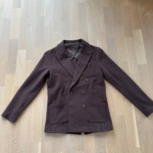 Kavaj John Henric i nyskick - Brun dubbelknäppt kavaj från John Henric. Denna är slutsåld, så går inte få tag på.. Nypris 1499 kr. Skick 9,5/10, använd ett par tillfällen bara