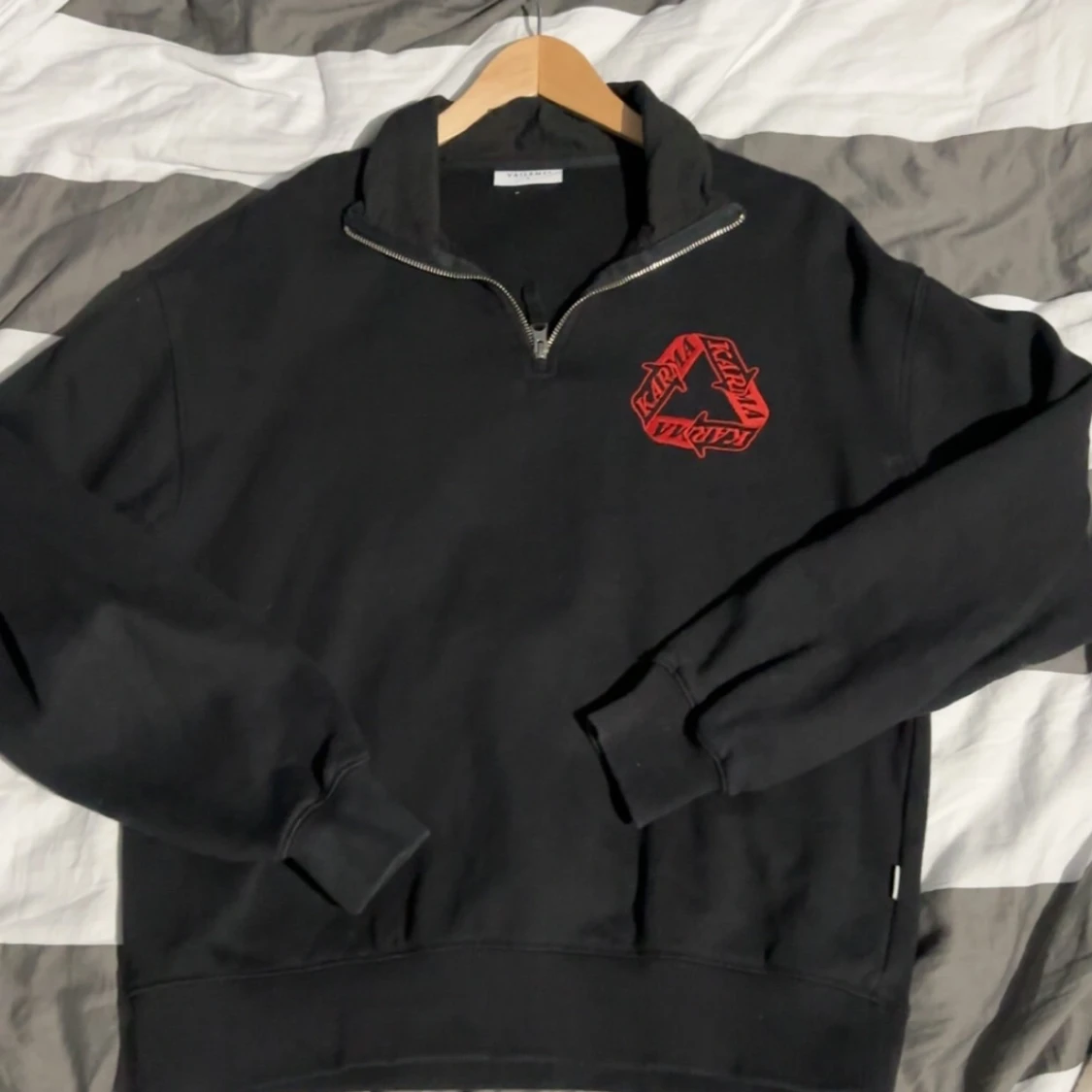 Svart tröja med dragkedja och röd logga