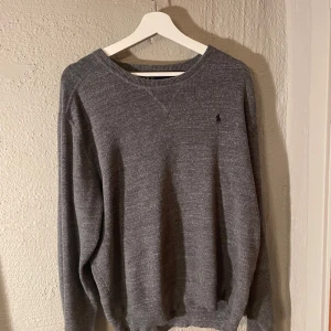 Grå tröja från Polo Ralph Lauren - Säljer en stilren grå tröja från Polo Ralph Lauren. Säljer för den inte används så många gånger.