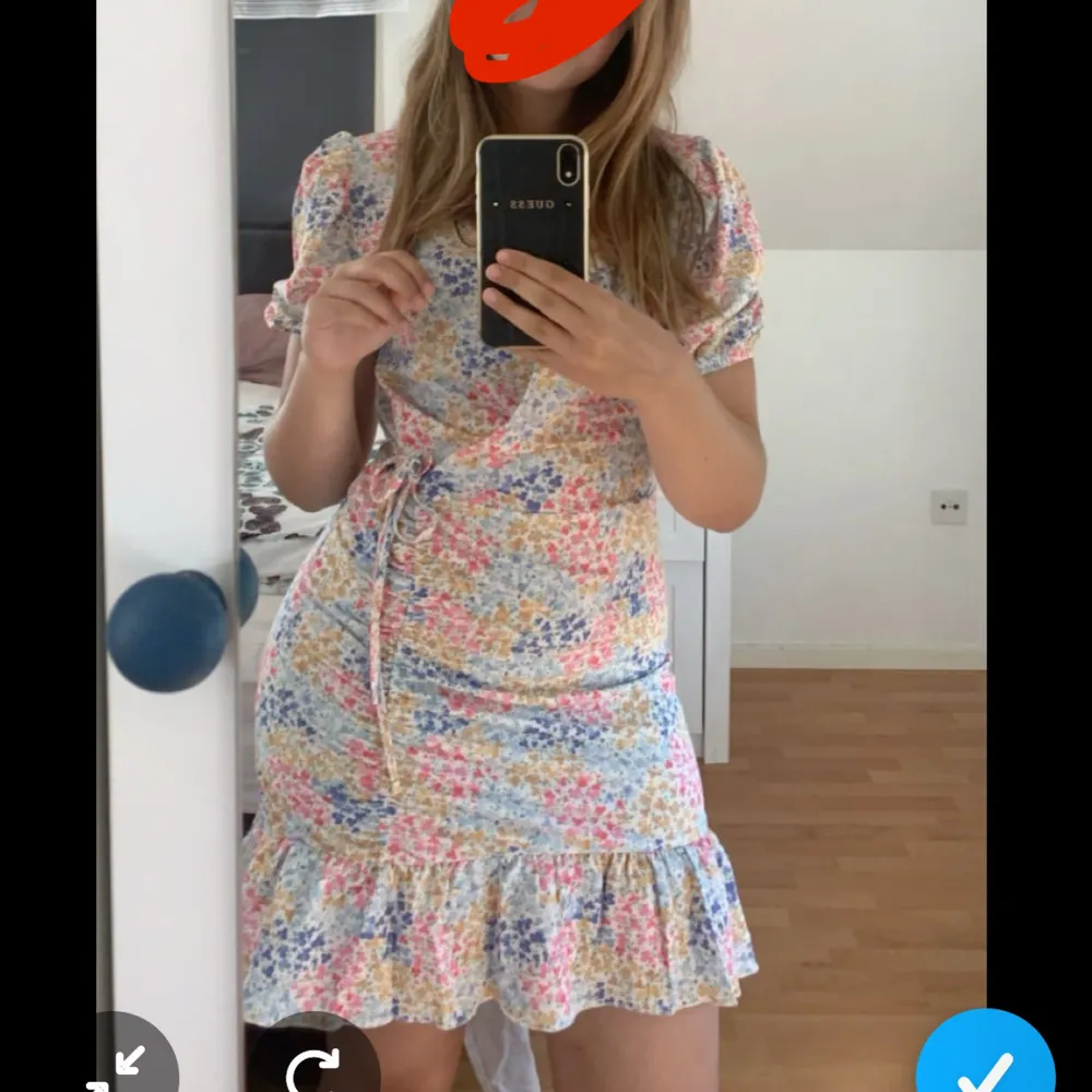Söt sommarklänning med puffiga ärmar o volanger vid slutte av klänningen. Klänningen ör knä lång och har snöre vid sidan som ger en omlott style. . Mekot.