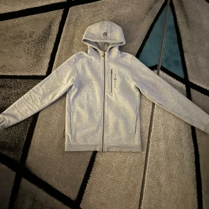 Grå huvtröja från Sail Racing - Säljer en stilren grå huvtröja från Sail Racing på grund av den inte används. Nypris 1000kr!