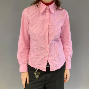 Rosa skjorta med knappar - Snygg rosa skjorta med klassisk krage och knappar framtill. Perfekt för en stilren look. Långärmad design som passar bra till både jeans och byxor.