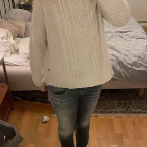 Vit stickad tröja från Hampton Republic - Säljer en mysig vit stickad tröja från Hampton Republic med flätmönster framtill. Tröjan har en hög krage och långa ärmar. 🤍