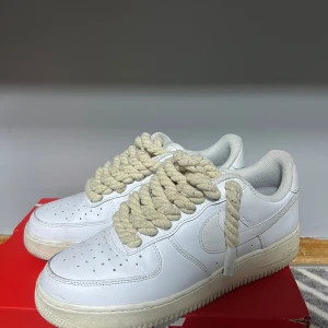 Vita Nike Air Force sneakers - säljer du nu dessa skor som är i använd skick super fina och jättesköna Jag har gjort om snörena och lagt till rep istället som ska göra skorna lite stiligare. Jag älskar denna design tyvärr kommer inte de gamla snörena med eller kartong och finns tyvärr ingen sula till skorna.