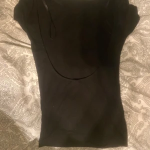 Svart kortärmad topp - Säljer en stilren svart topp med korta ärmar, men kan öppen bak från Gina tricot❤️