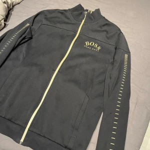 Svart kofta från Hugo Boss - Snygg svart kofta från Hugo Boss, den gammal modellen som ej finns o köpa längre, pris går o diskutera vid snabb affär ! Storlek L men passar M oxå! skick 8,5/10