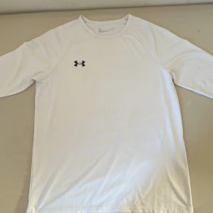 Vit långärmad tröja från Under Armour - Använt sparsamt och har en liten defekt på en av ärmarna. Säljer eftersom den är för stor; jag skulle säga att den passar som storlek M.