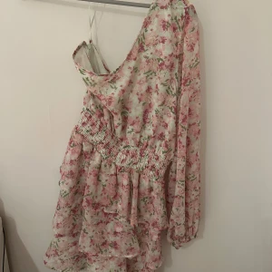 Klänning  - Blommig klänning med en ärm, från Gina tricot. Storlek 40