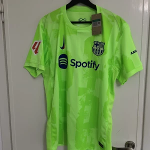 barca tredje ställ 24/25 - Säljer en jättefin och helt ny oanvänd barca tredje ställ tröja med raphina 11 på ryggen och laliga loggan på armen. tröjan är topp kvalité och är slimfit. storleken är XL men passar mer till L
