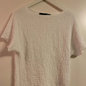 Vit texturerad topp från 157 - Säljer en vit topp från 157 med en unik textur som är väldigt skön att bära! Nyskick! Strl S